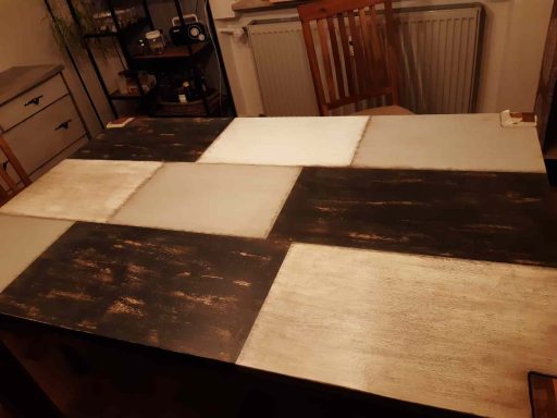 Holztisch mit unterschiedlichen Farbflächen in Grau, Schwarz und Weiß.