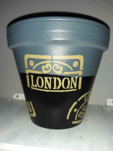 Bunter Blumentopf mit dem Schriftzug "LONDON" und dekorativen Grafiken.