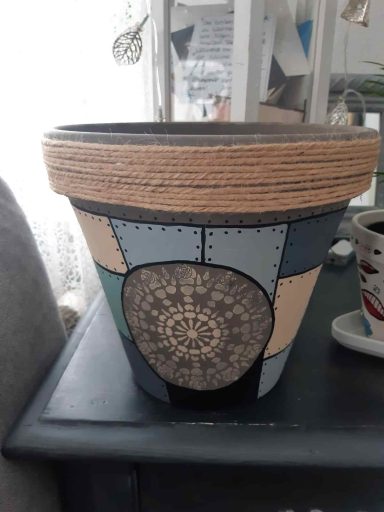 Bunter Blumentopf mit einem dekorativen Muster aus runden und geometrischen Formen.