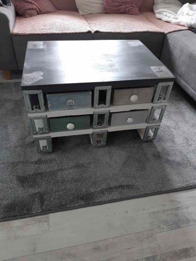 Ein quadratischer Couchtisch aus Paletten mit Schubladen in verschiedenen Farben.