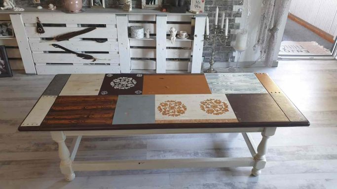 Holztisch mit buntem Patchwork-Design und verschiedenen Mustern und Farben.